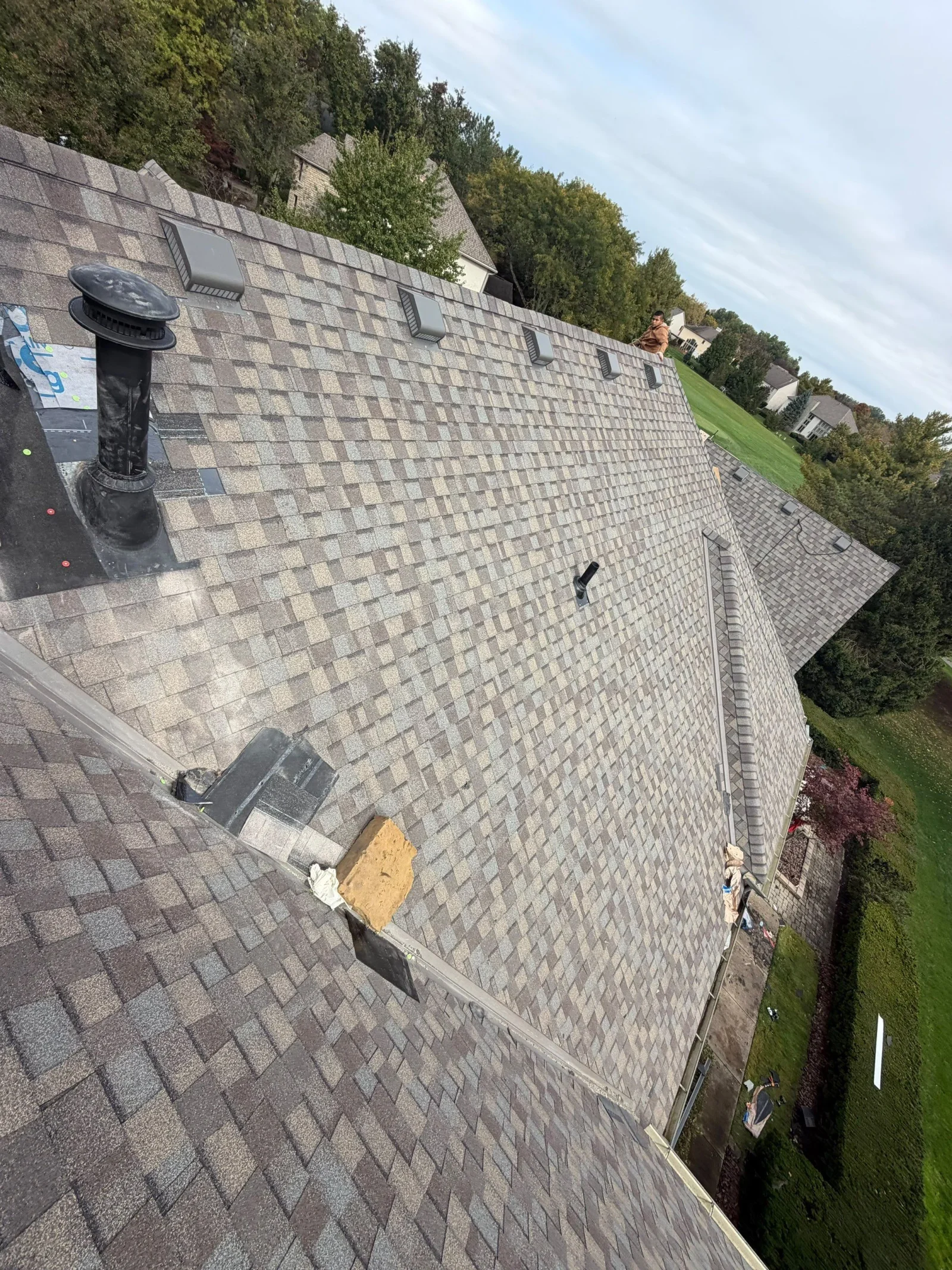 Architectural asphalt shingle roof with gray box vents, black pipe flashing, and black membrane at plumbing stack base