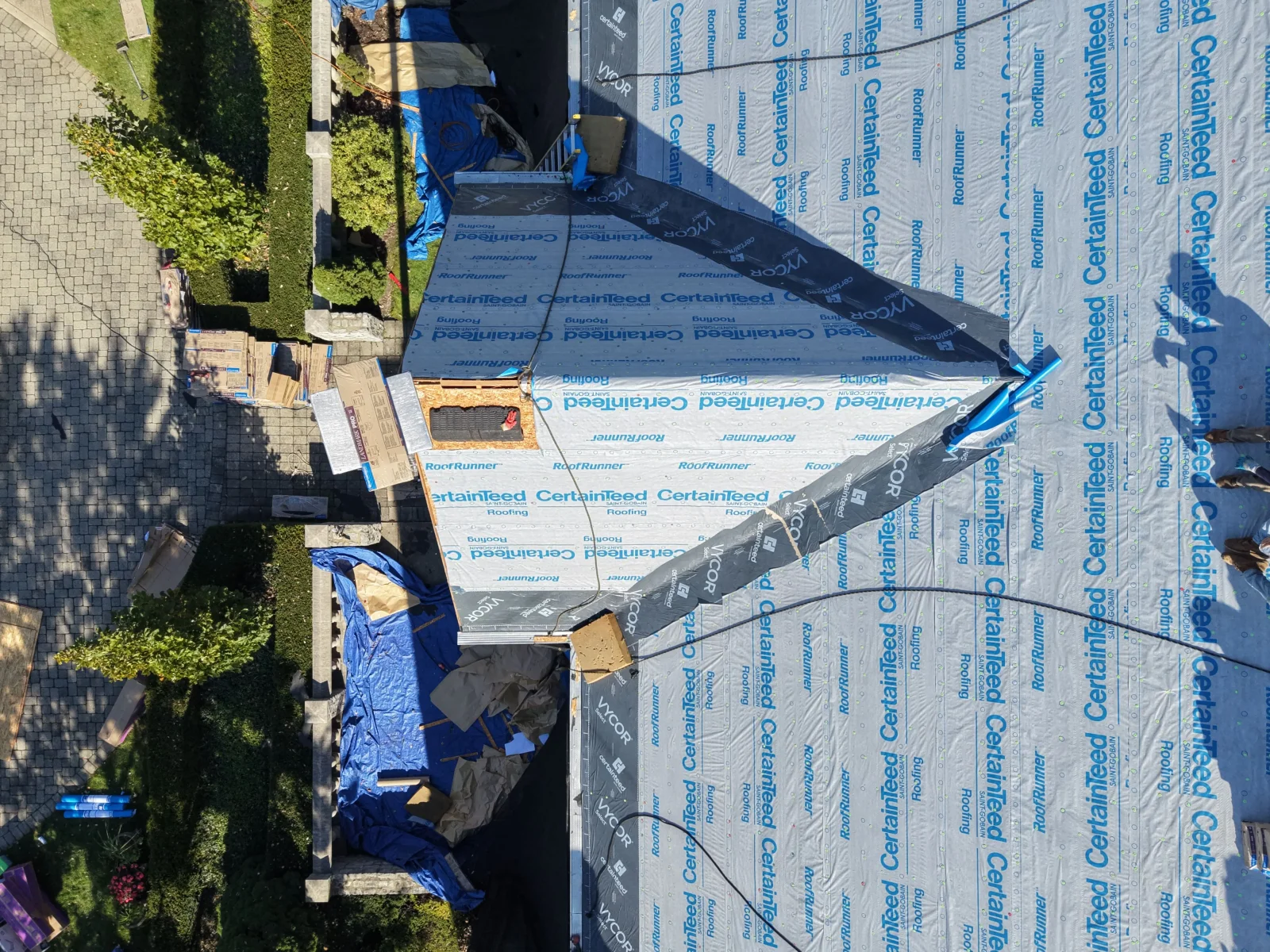 Aerial view of roof deck with CertainTeed RoofRunner synthetic underlayment and Vycor ice and water barrier membrane during installation